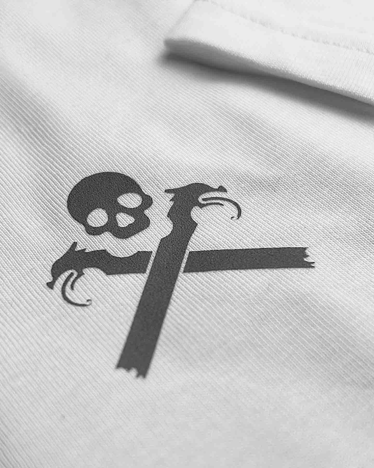 Macro shot of the skull logo on white Essentials T-Shirt, highlighting the minimalist design